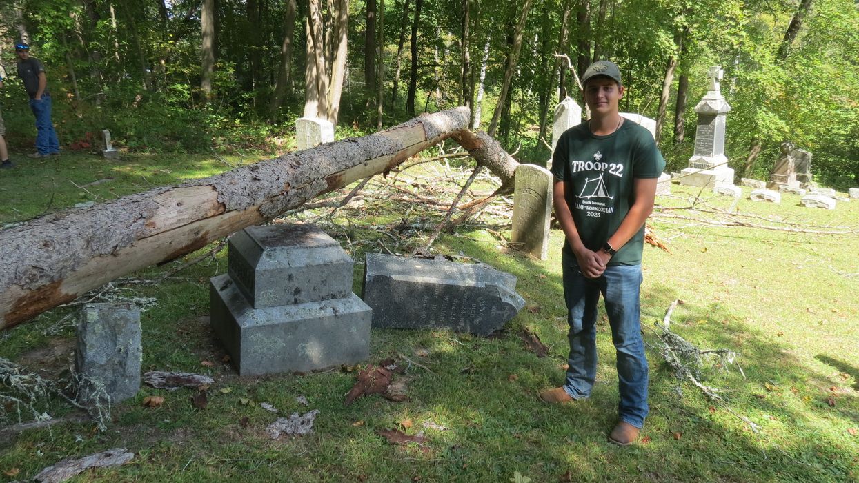 Scout repairs fallen tombstones