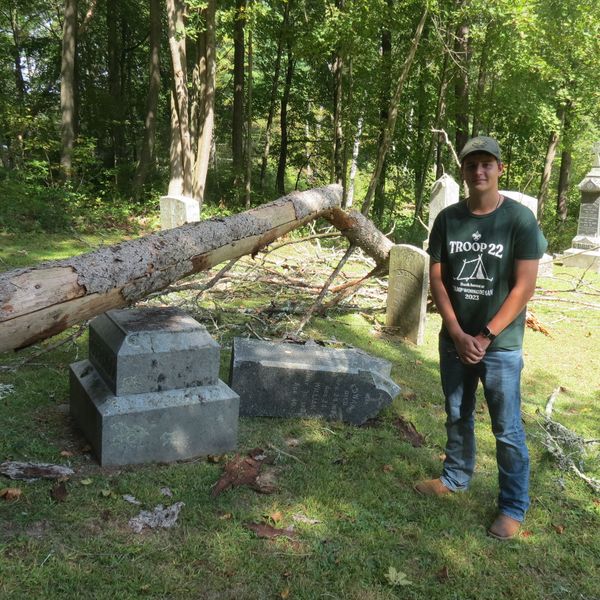 Scout repairs fallen tombstones