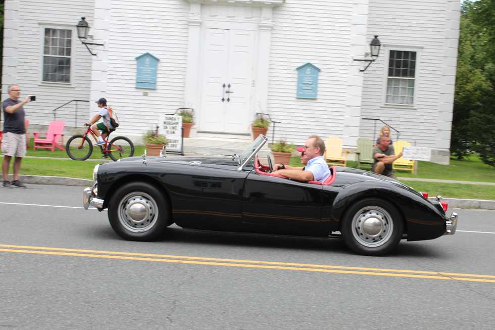 Waving as historic cars parade through town